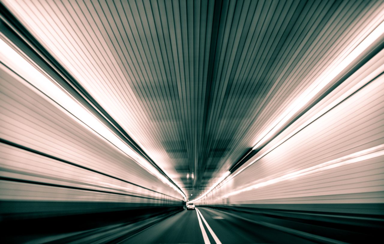 about-01 Speeding through a futuristic tunnel with blurred lines conveying movement and velocity.