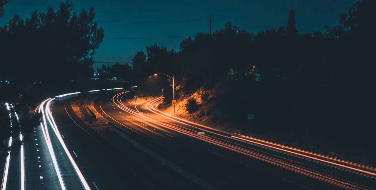 gallery-6 Captivating long exposure photo of a highway at night showcasing vibrant light trails from moving cars.