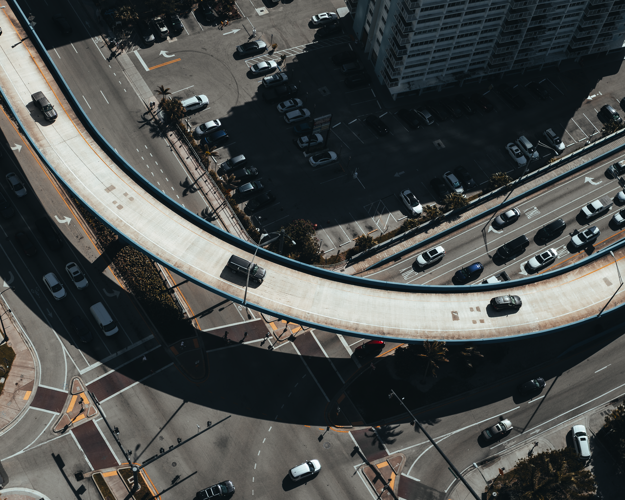 services-03 Aerial view showcasing a bustling urban elevated road intersection with busy traffic.